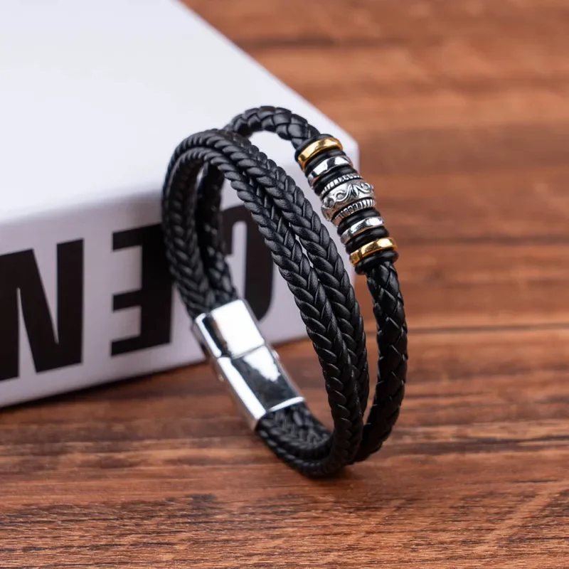 Pulsera triple trenza negra con apliques plateados y dorados